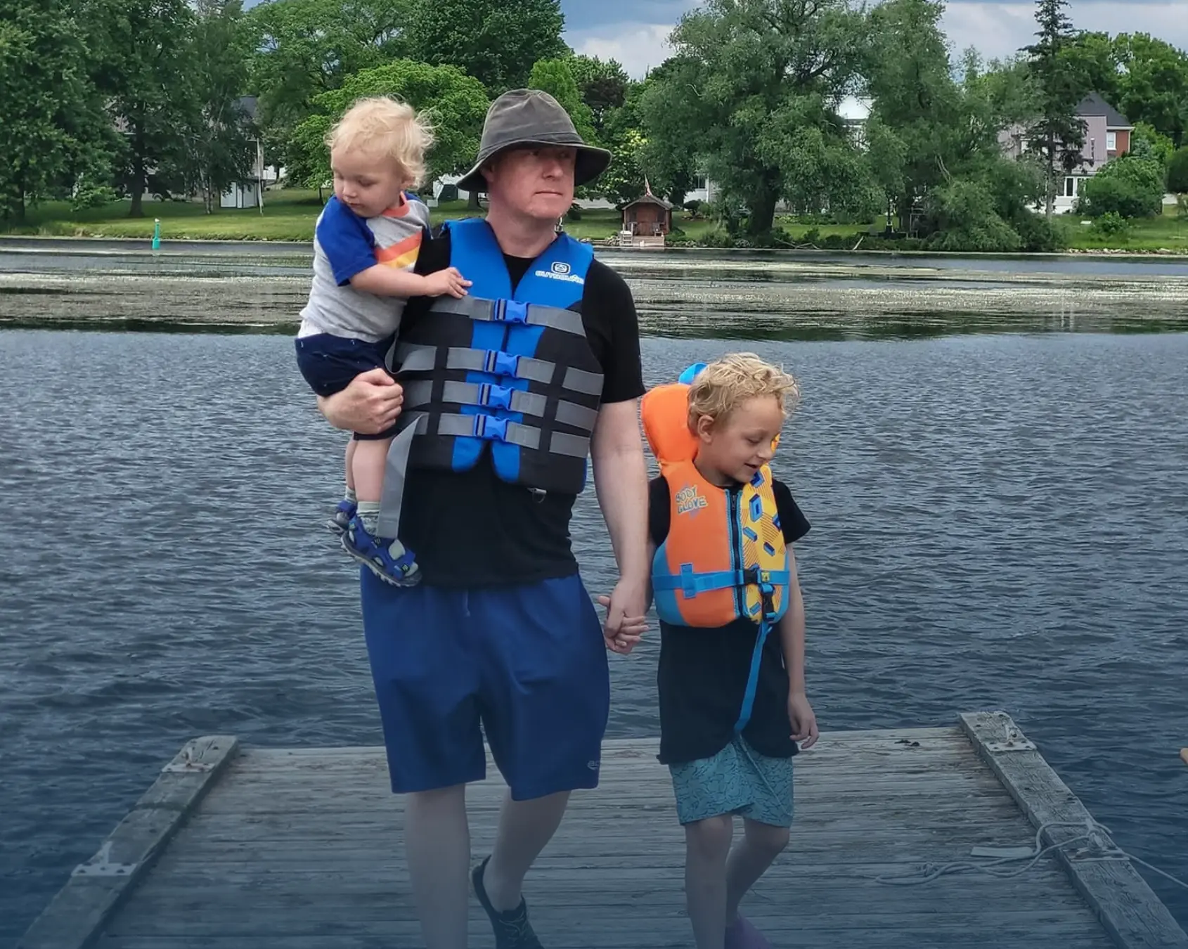 Nate Morris on a dock with his two young sons in life jackets